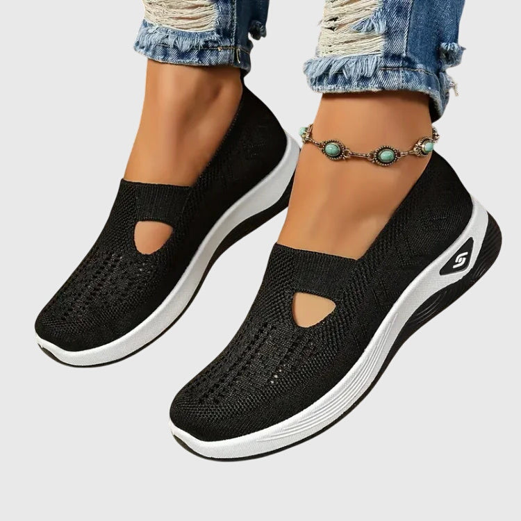 Black slip-on orthopedic walking shoe, knit upper with open toe cutouts, white sole.