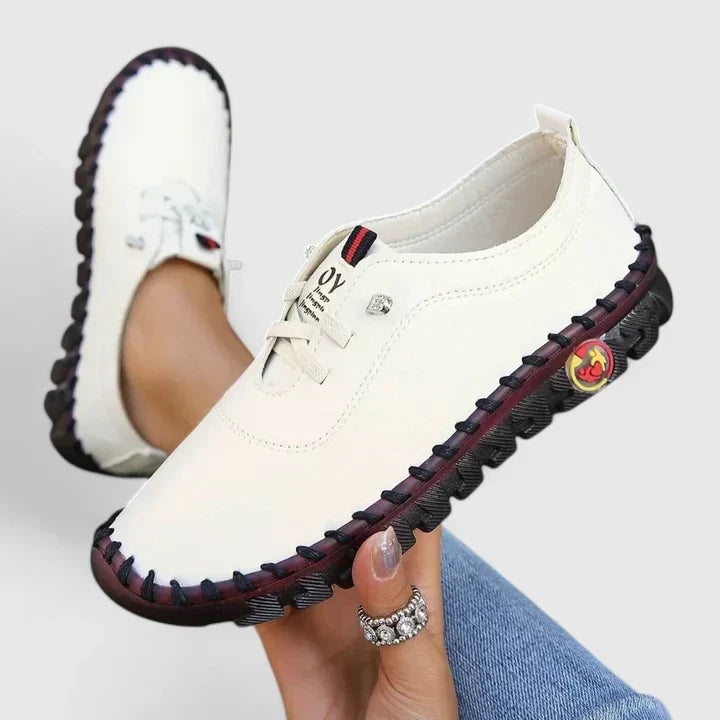 White leather lace-up casual shoes with black sole trim and side emblem
