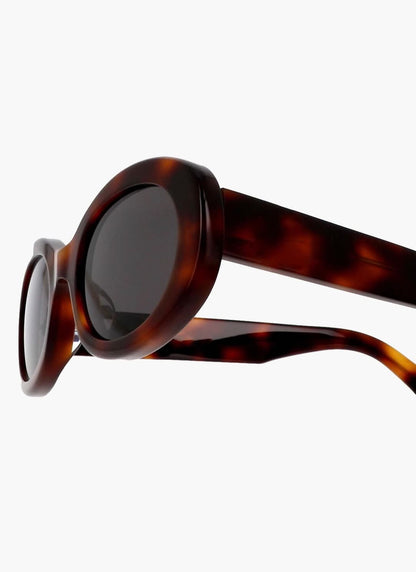 Tortoise sunglasses side view with dark oval lens and curved temple arm