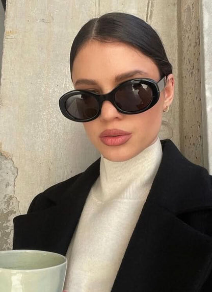 Black oval sunglasses with dark lenses worn by model, cat-eye silhouette