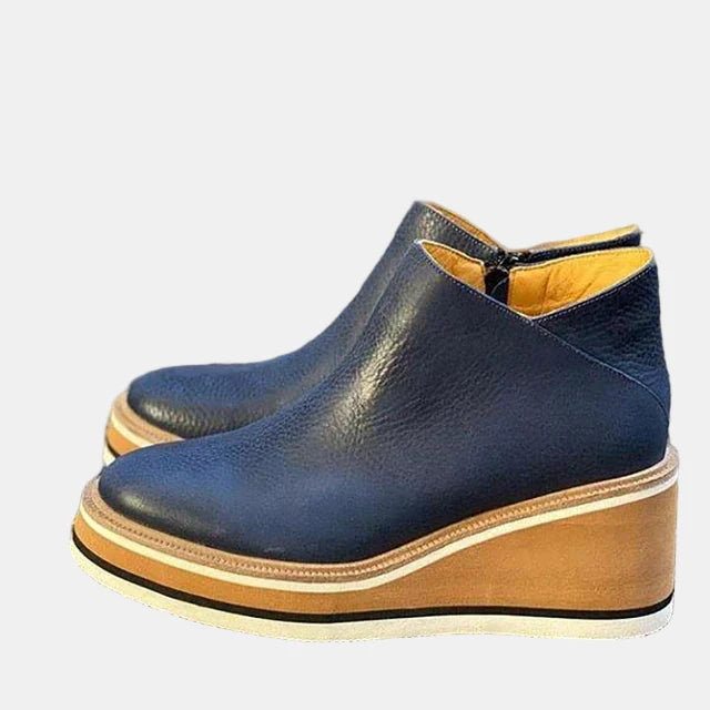 Dark blue ankle boots with side elastic, pull-on opening, and tan platform sole.