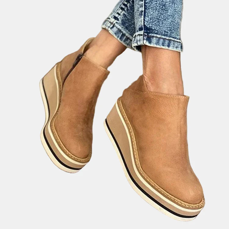 Beige ankle boots with side elastic, slip-on design, and stacked platform heel.