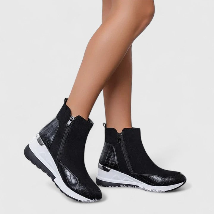 Black orthopedic ankle boots with side zipper and cushioned white sole.