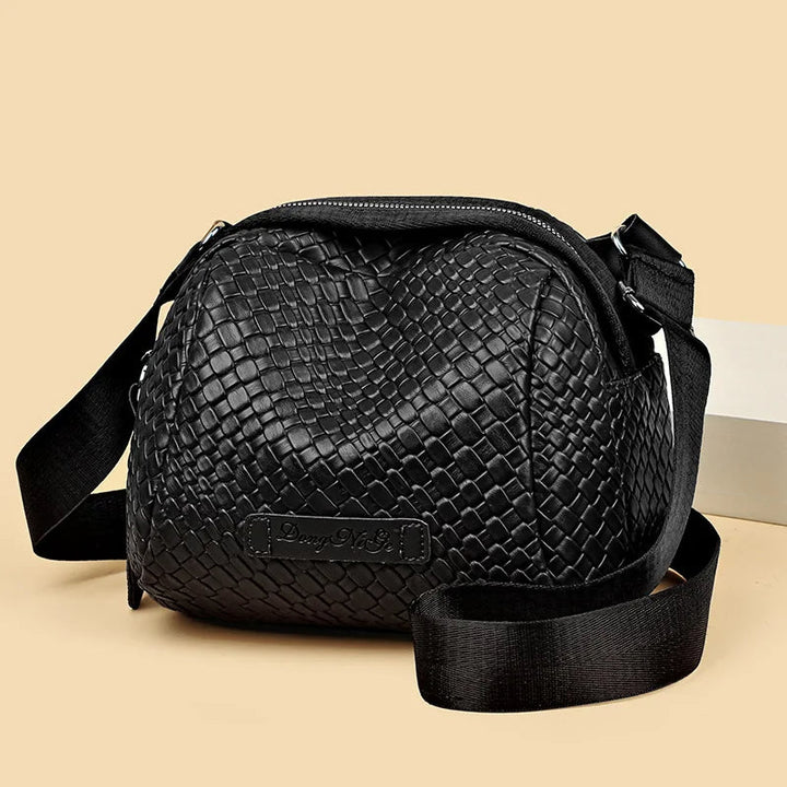 Black woven-texture shell crossbody bag with zip top and adjustable shoulder strap