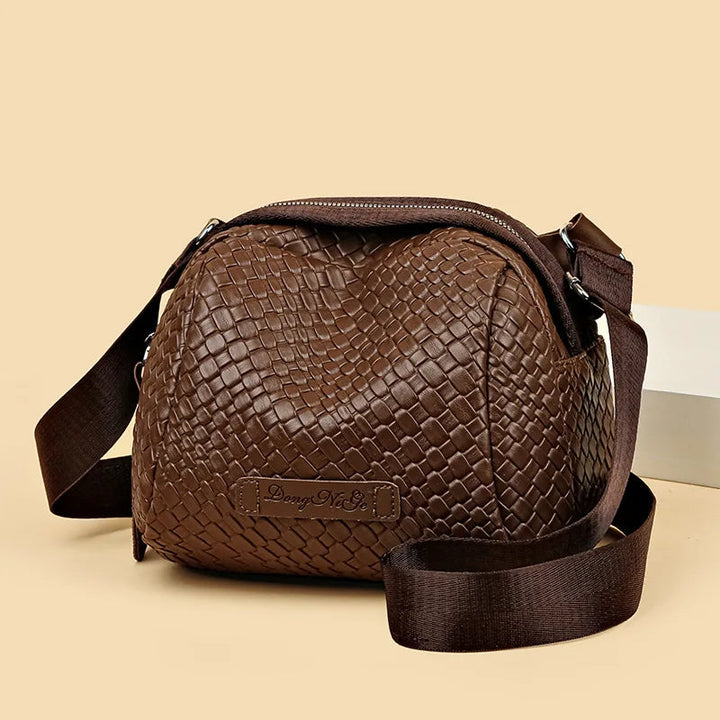 Brown woven-texture shell crossbody bag with zip top and adjustable shoulder strap