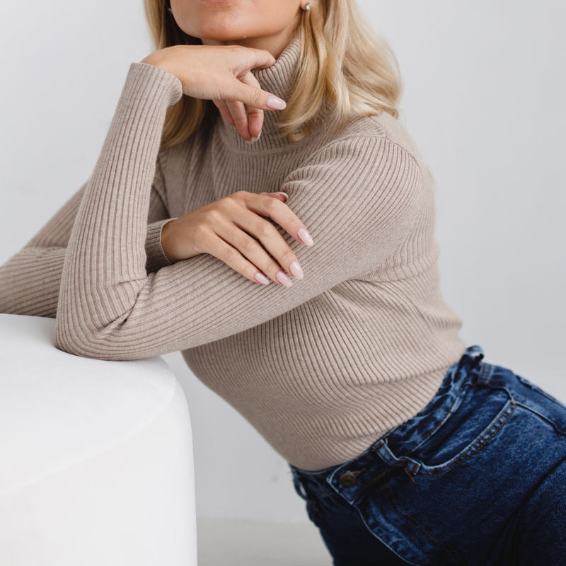 Beige ribbed turtleneck sweater with long sleeves and a high, close neckline