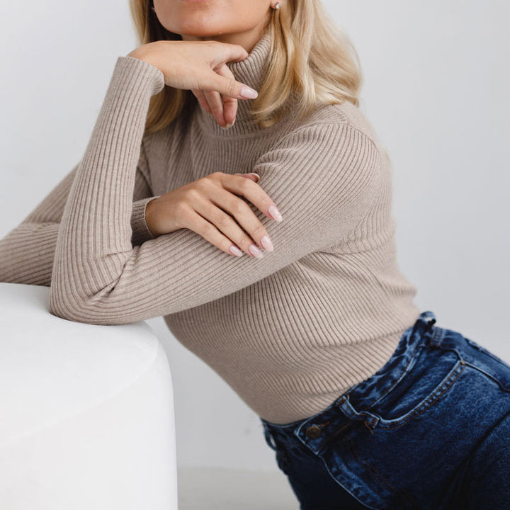 Beige ribbed turtleneck sweater with long sleeves and a high, close neckline