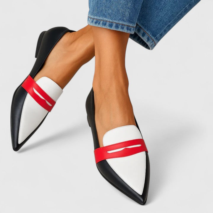 White leather loafers with black trim and red strap detail