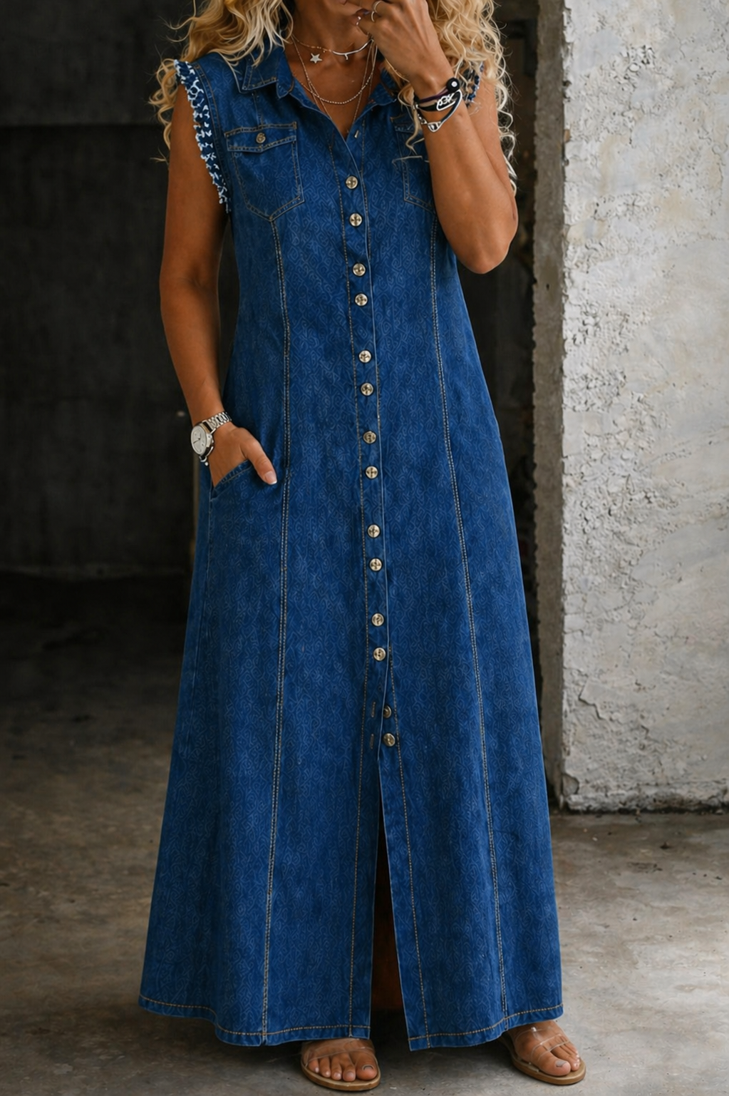 Medium-wash denim maxi dress with sleeveless button front, pointed collar, side slit