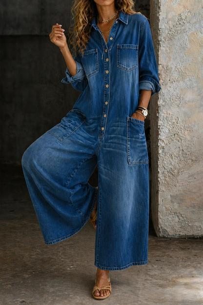 Dark blue denim jumpsuit with button-front and chest pocket, relaxed wide legs