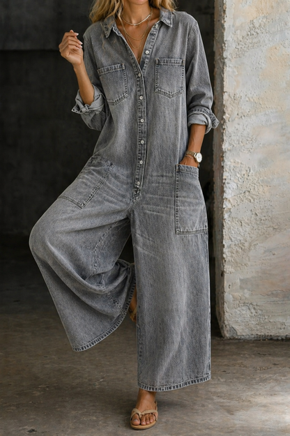 Gray denim jumpsuit with button-front, chest pockets, and wide-leg draped silhouette