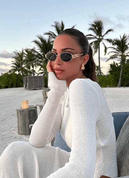 Round sunglasses on face with dark lenses and thin gold frame