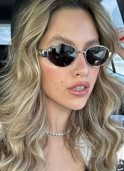 Round sunglasses on face with dark lenses and silver frame