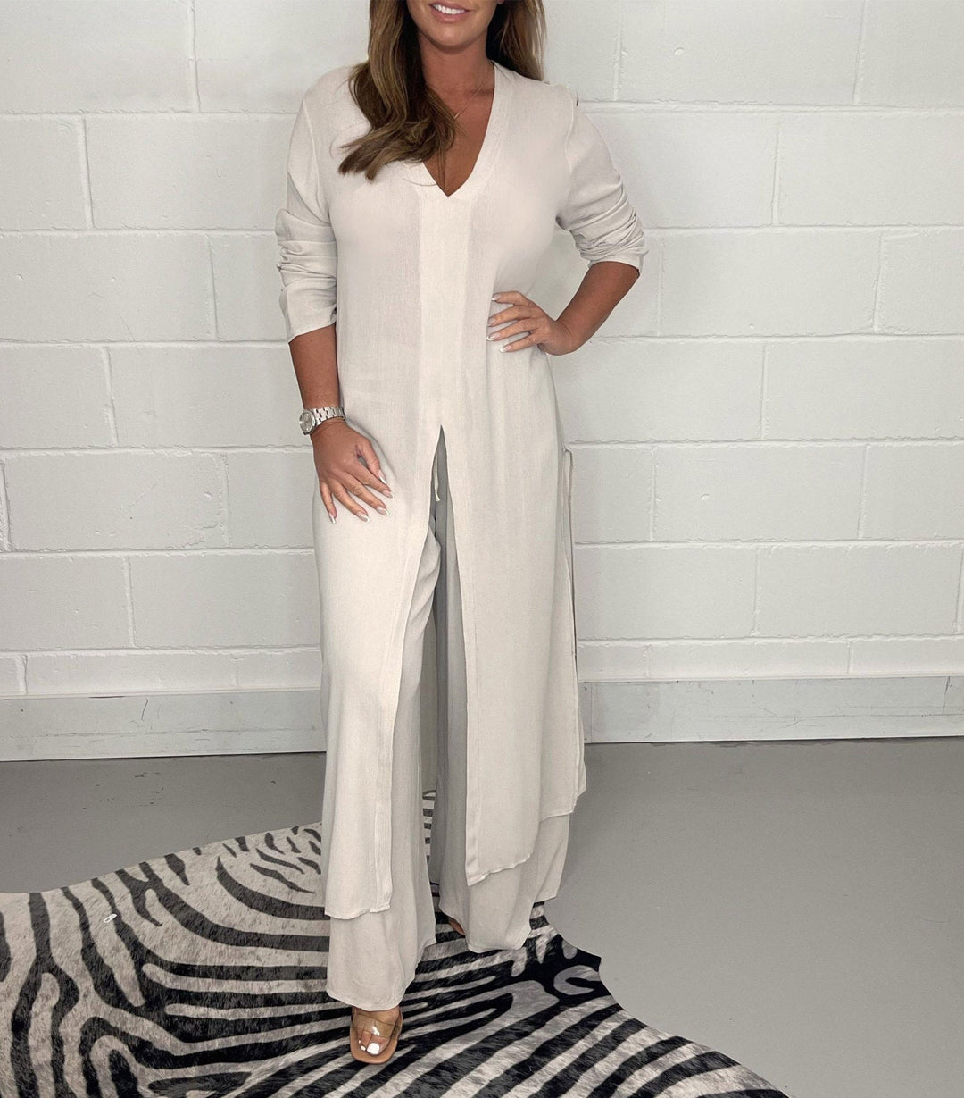 Cream two-piece set with V-neck flowy blouse and wide-leg trousers, side slit