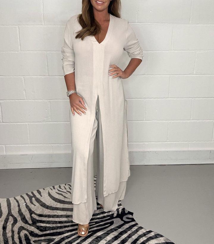 Cream two-piece set with V-neck flowy blouse and wide-leg trousers, side slit