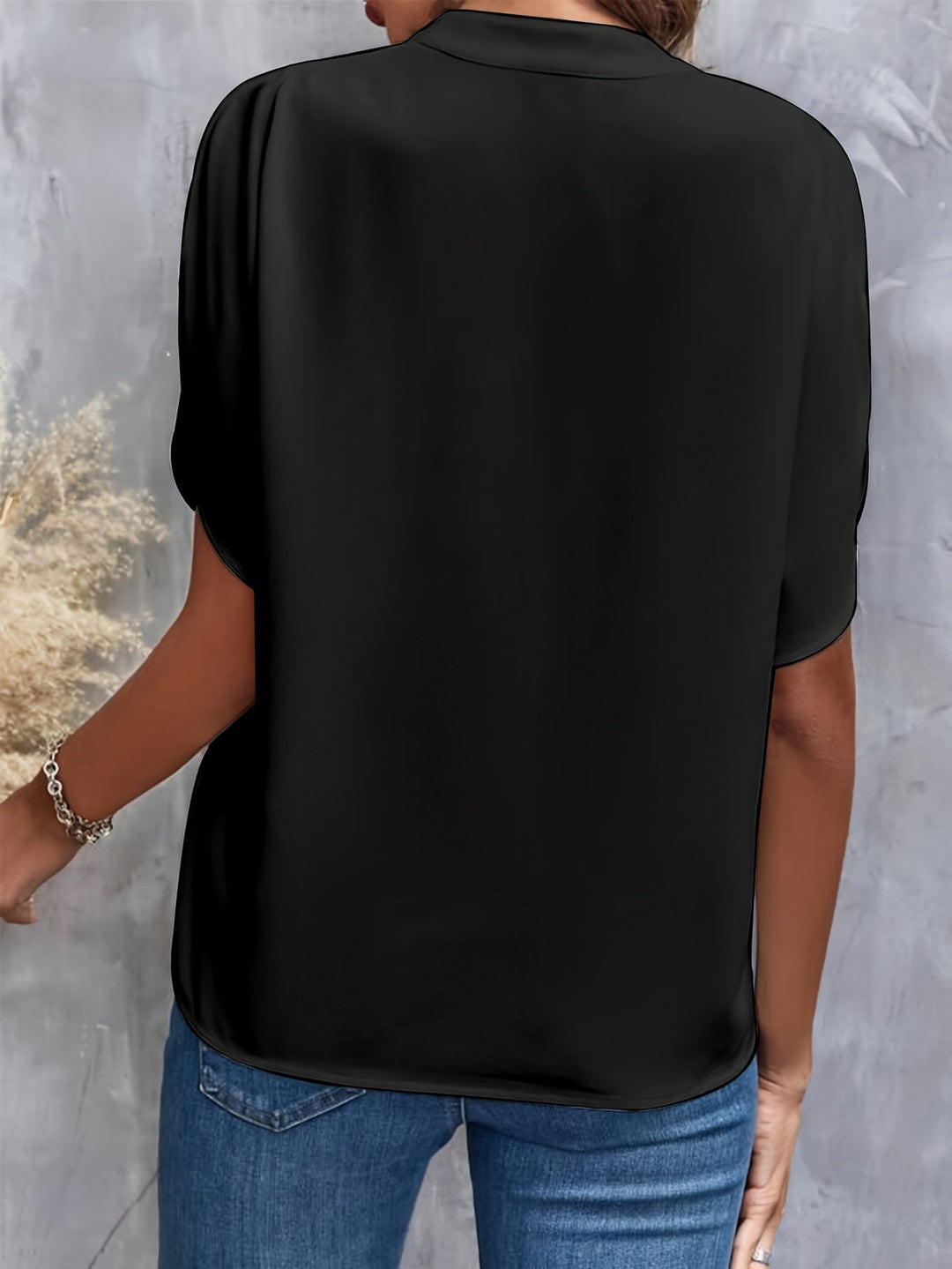 Black women’s luxe flared top with V-neck, short draped sleeves, back view