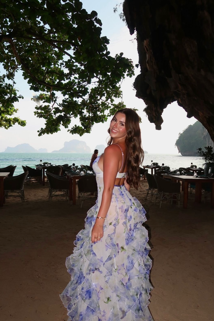 Blue floral ruffled maxi dress with thin straps and tiered skirt from side view