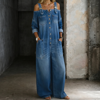 Blue off-shoulder denim jumpsuit with button front, chest pockets, wide-leg fit.