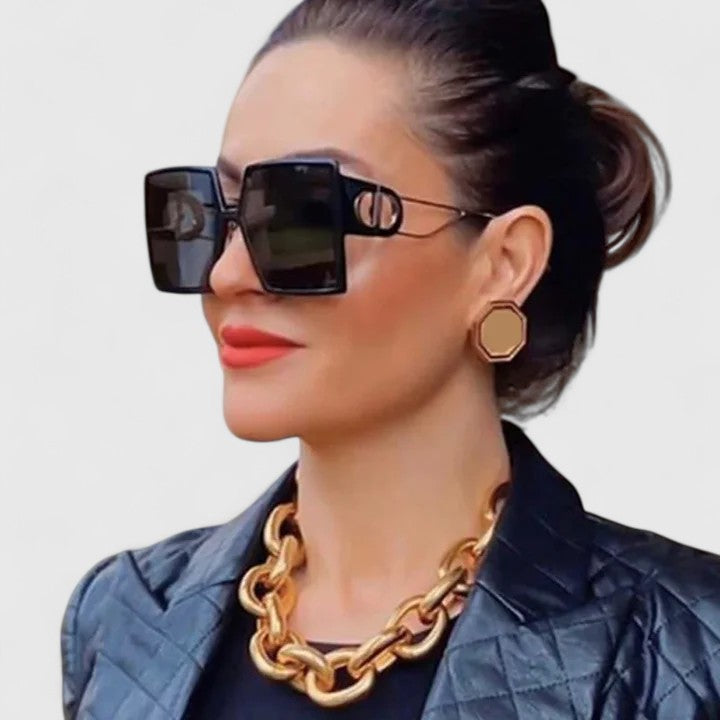 Square dark sunglasses with gold hinge detail and large black lenses