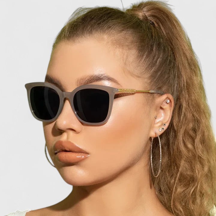 Dark cat-eye sunglasses with black lenses and gold-tone slim arms