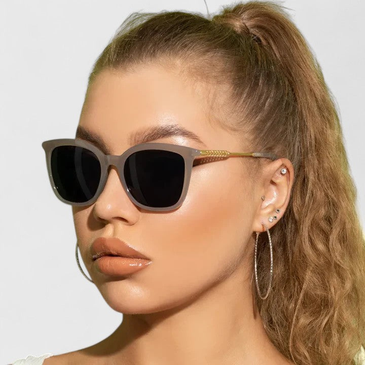 Dark cat-eye sunglasses with black lenses and gold-tone slim arms