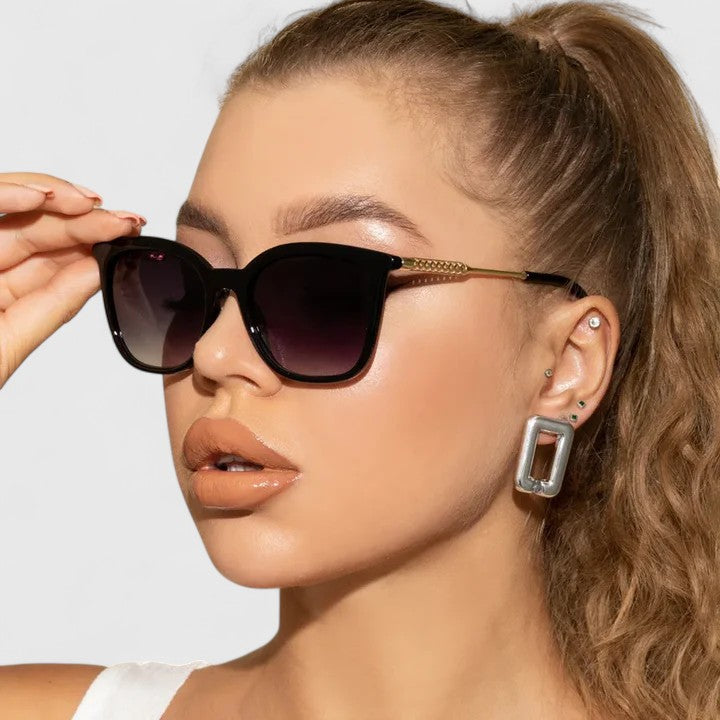 Black cat-eye sunglasses with dark lenses and gold-tone arms