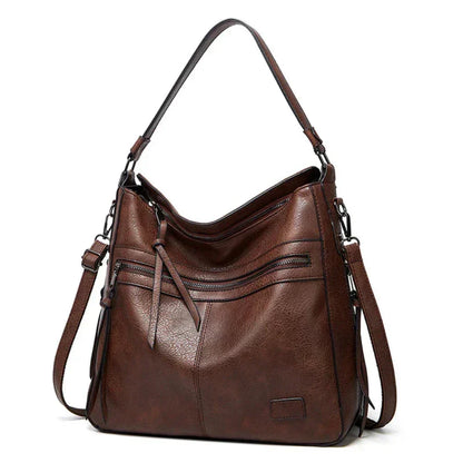 Dark brown hobo shoulder bag with front zip pockets, tassel detail, and side straps