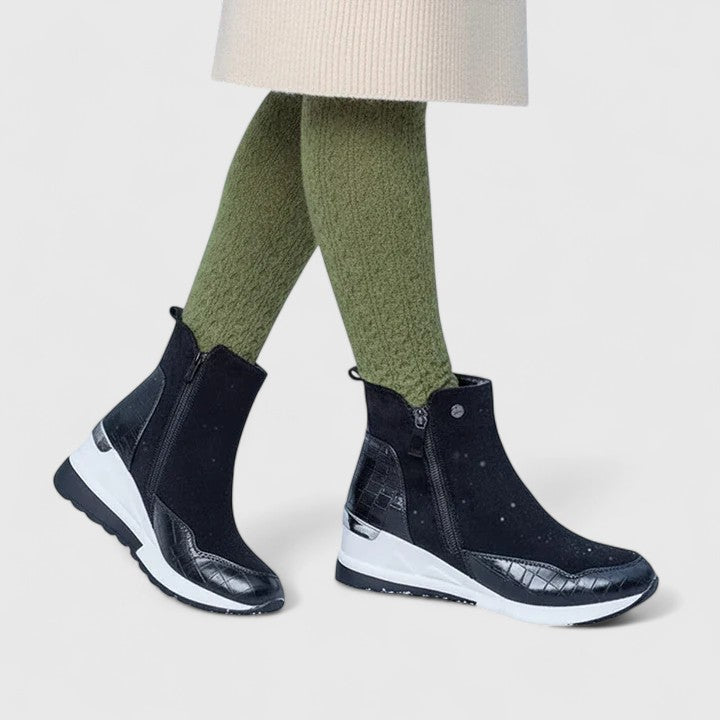 Dark orthopedic ankle boots with side zipper and white cushioned sole.