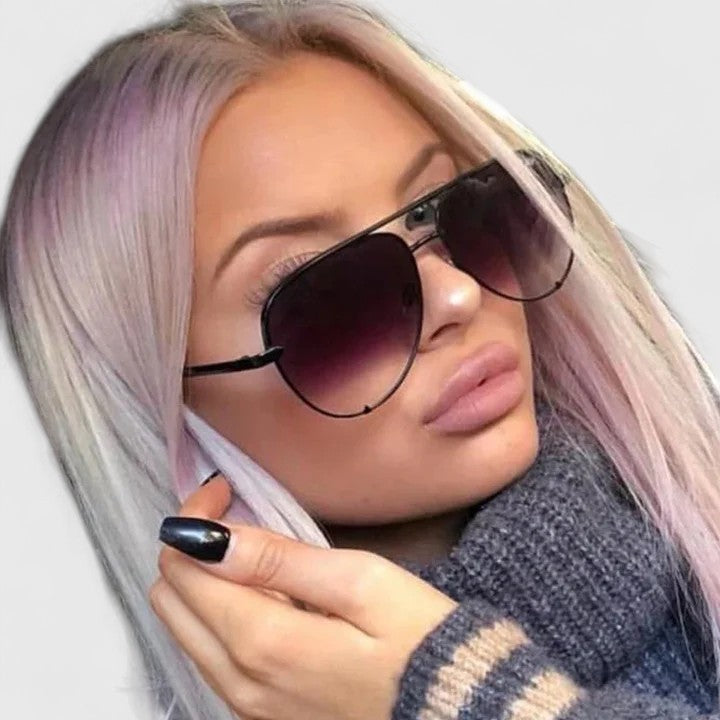 Person wearing black sunglasses with dark lenses and thin metal aviator frames