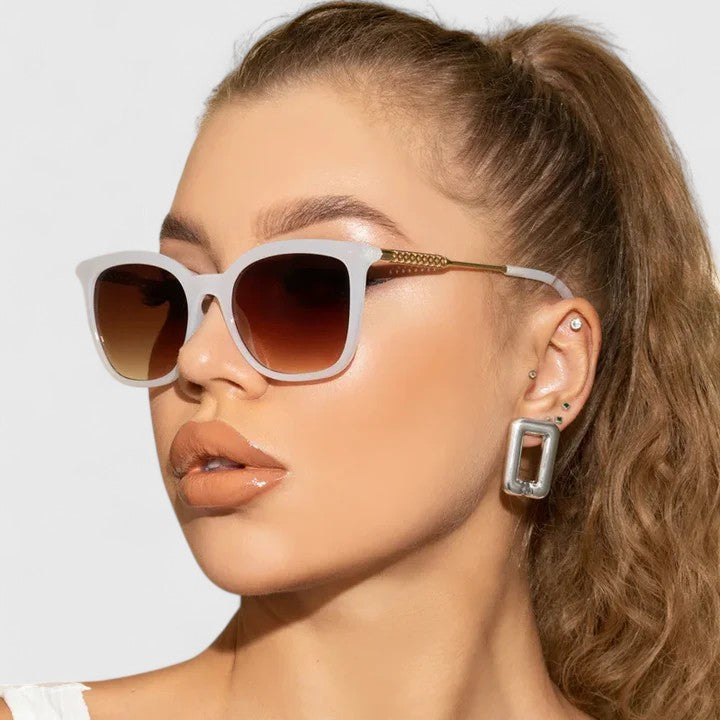 White cat-eye sunglasses with brown tinted lenses and gold-tone arms