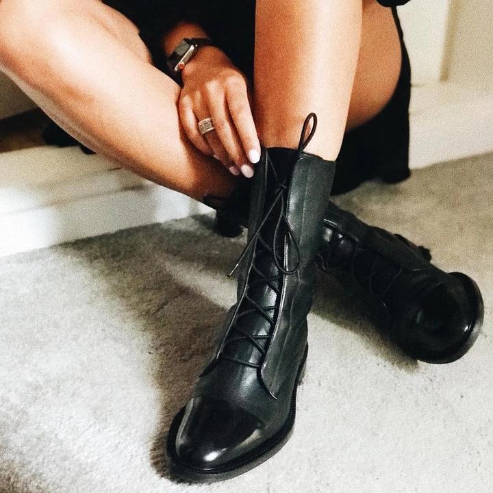 Black lace-up heeled boots with pointed toe and glossy finish