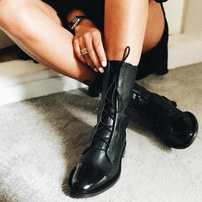 Black lace-up heeled boots with pointed toe and glossy finish