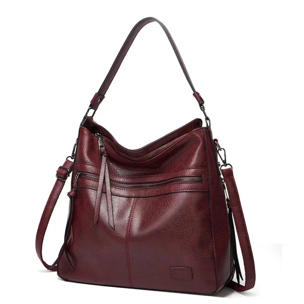 Burgundy hobo shoulder bag with front zip pockets and two adjustable shoulder straps