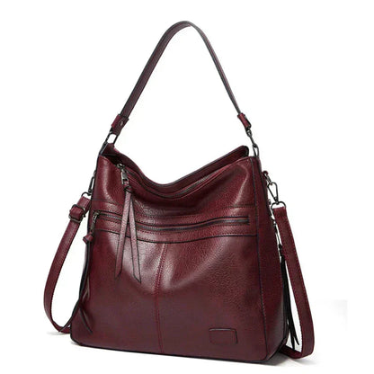 Burgundy hobo shoulder bag with front zip pockets and two adjustable shoulder straps