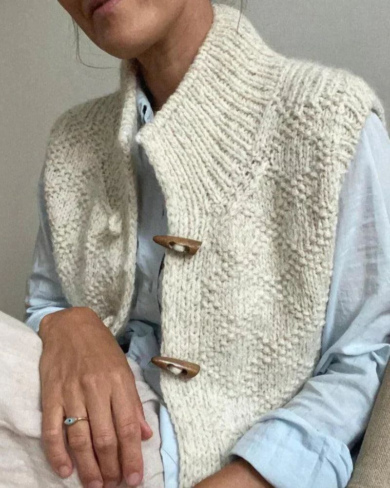 Cream textured sleeveless cardigan with two visible front toggle buttons