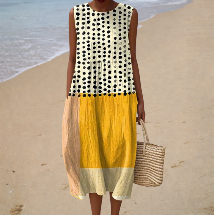 Sleeveless dress with black polka-dot top, yellow paneled skirt, round neckline, midi length