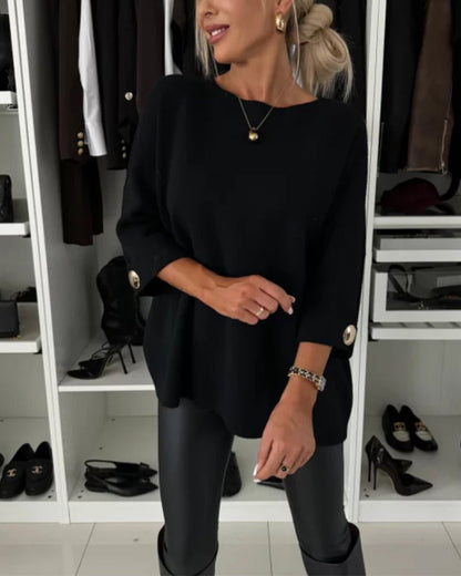 Black pullover sweater with round neck and buttoned sleeve accents.