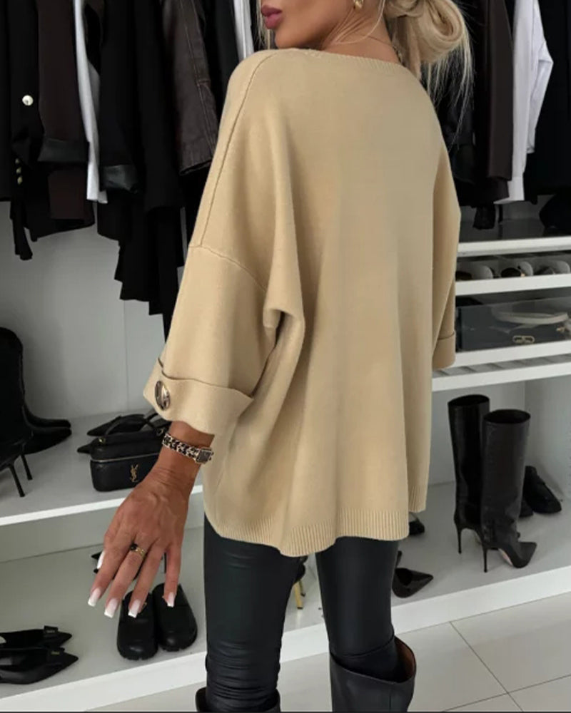 Beige cosy buttoned pullover sweater viewed from side, loose fit and cuff buttons