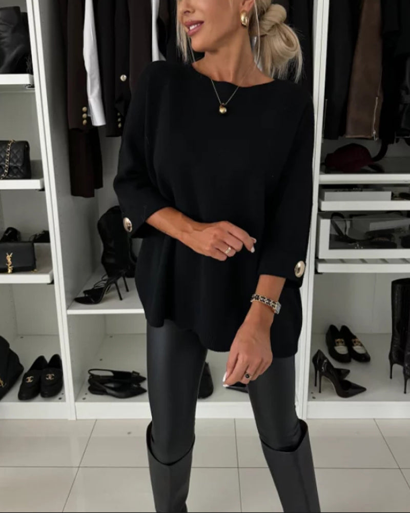 Black pullover sweater with buttoned cuff detail and round neckline.