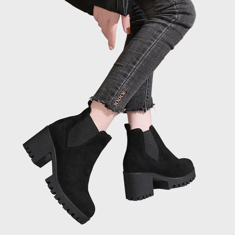 Black block-heel short boots shown from back quarter, with elastic gore and tread