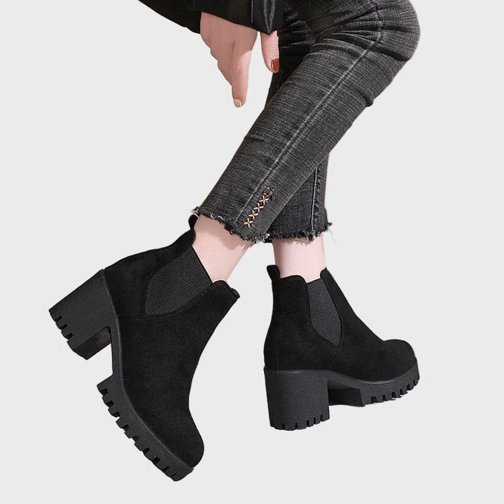 Black block-heel short boots shown from back quarter, with elastic gore and tread