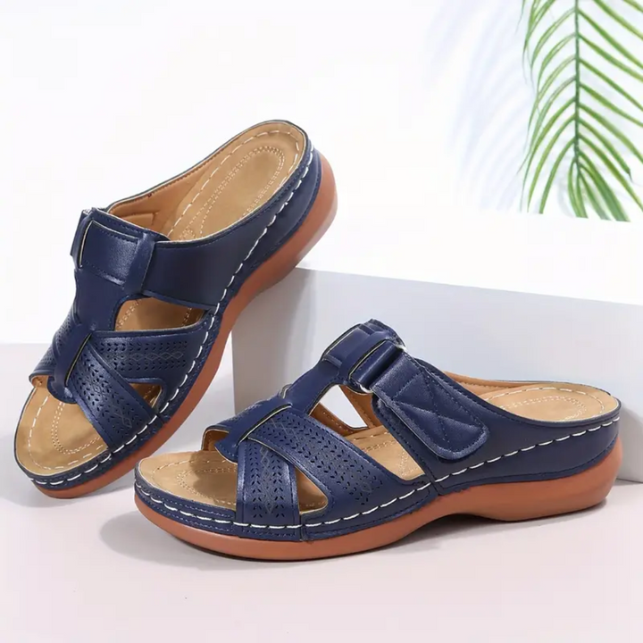 Navy ergonomic sandals with two wide straps, perforated upper, and tan footbed