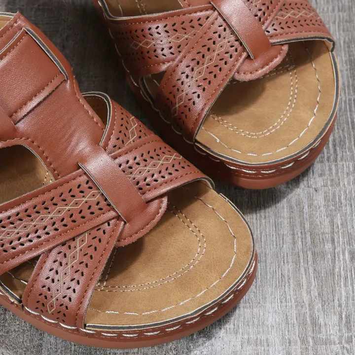 Brown ergonomic sandals close-up with perforated upper and double strap buckle