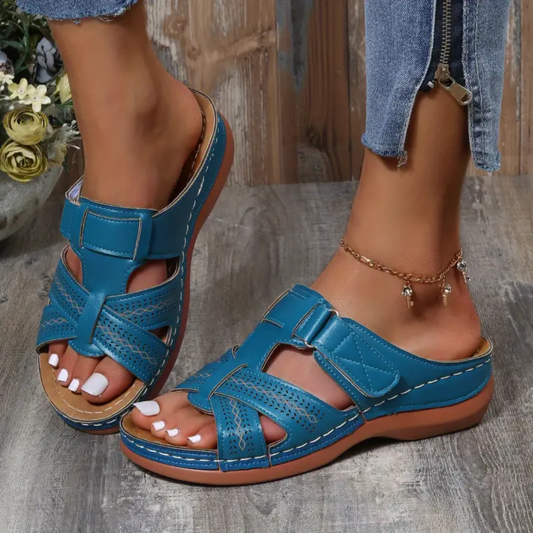 Blue ergonomic sandals with double straps, perforated toe, and stitched sole