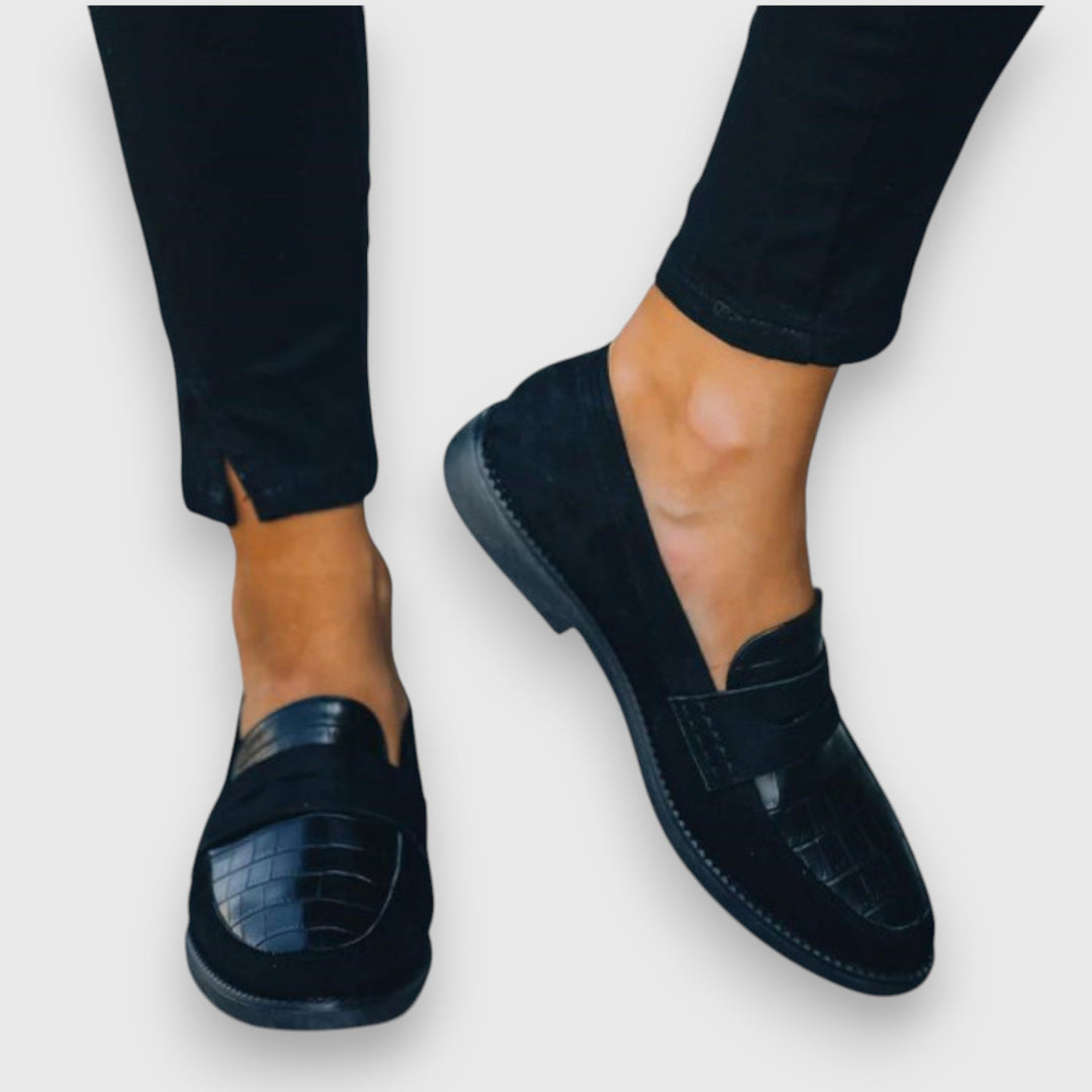 Dark moccasin shoe with double strap and flat sole, side view