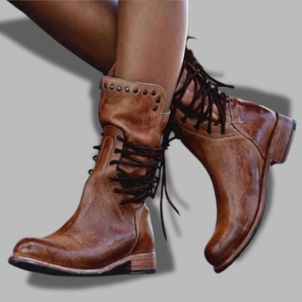 Brown leather lace-up boots with studded strap detail and rugged tread sole.