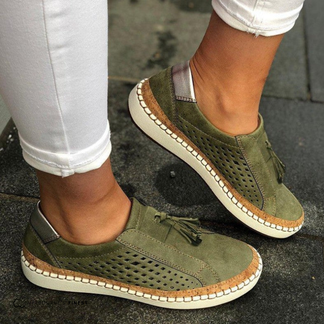 Green orthopedic slip-on shoes with tassel detail, perforated upper, and cream sole