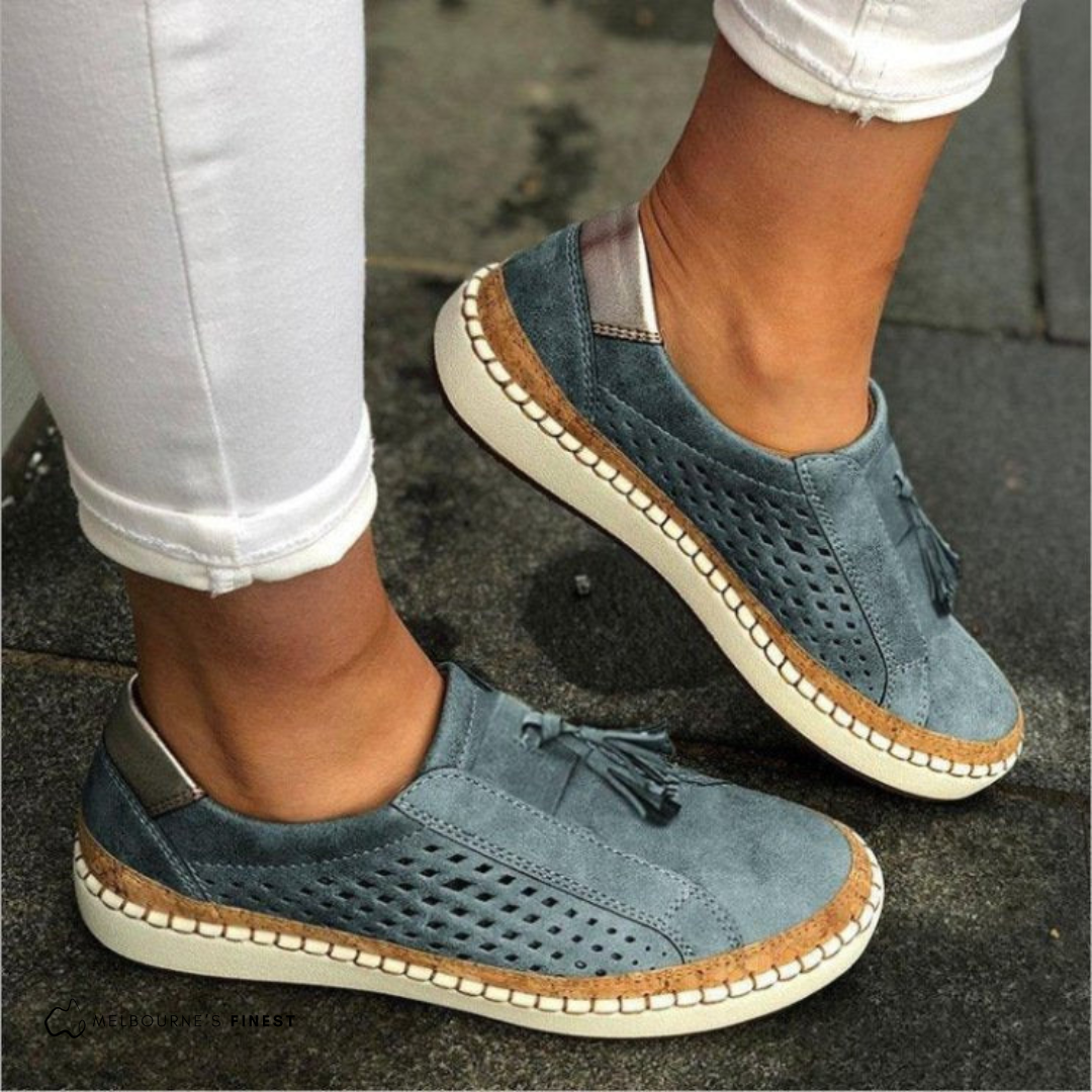 Blue orthopedic slip-on shoes with tassel detail, perforated upper, and cream sole