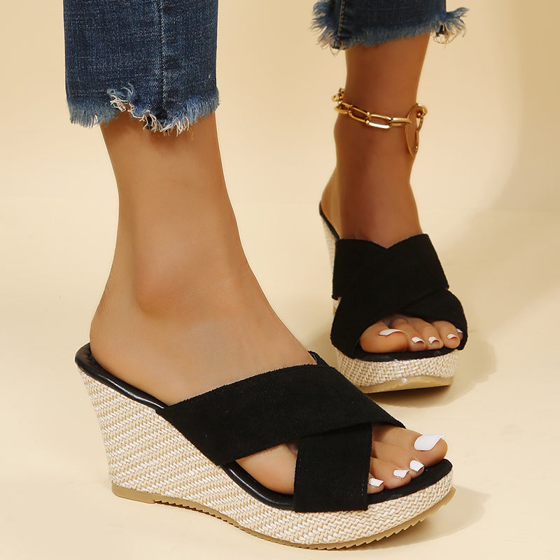 Black relaxed wedge sandals with ankle buckle strap, open toe, crossover elastic straps.