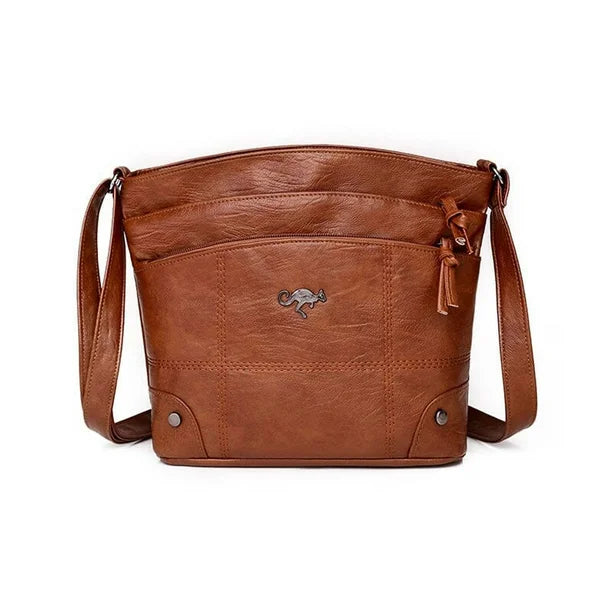 Brown leather crossbody bag with multiple pockets, zip top, and tassel pull.